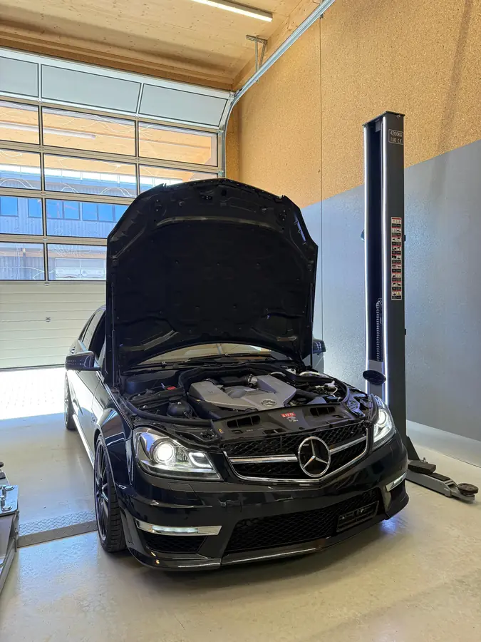 Mercedes-AMG mit offener Motorhaube in der Werkstatt