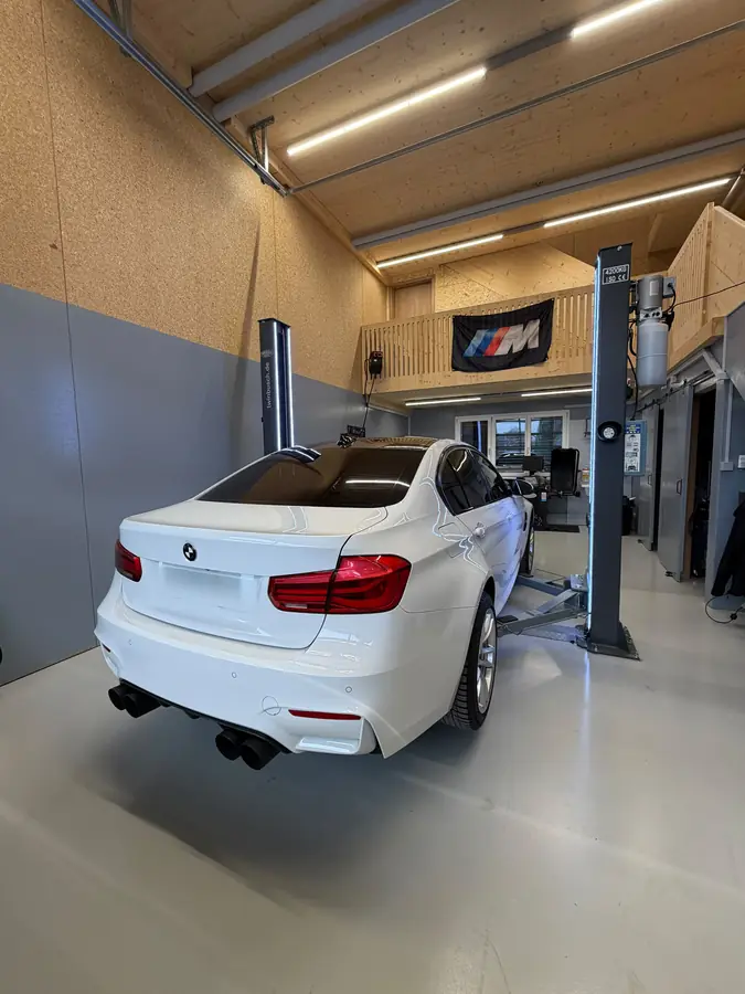 Weisser BMW M3 von hinten in der Werkstatt